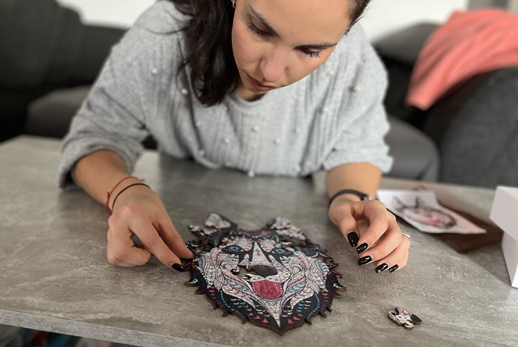 Egy husky formájú allatos fa puzzle kirakás közben.